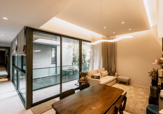 Wide-angle listing photo of a dining area opening to a balcony